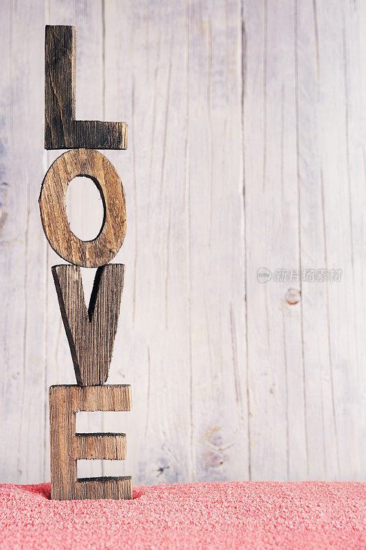 “爱”这个词用木字写在一个乡村的背景上