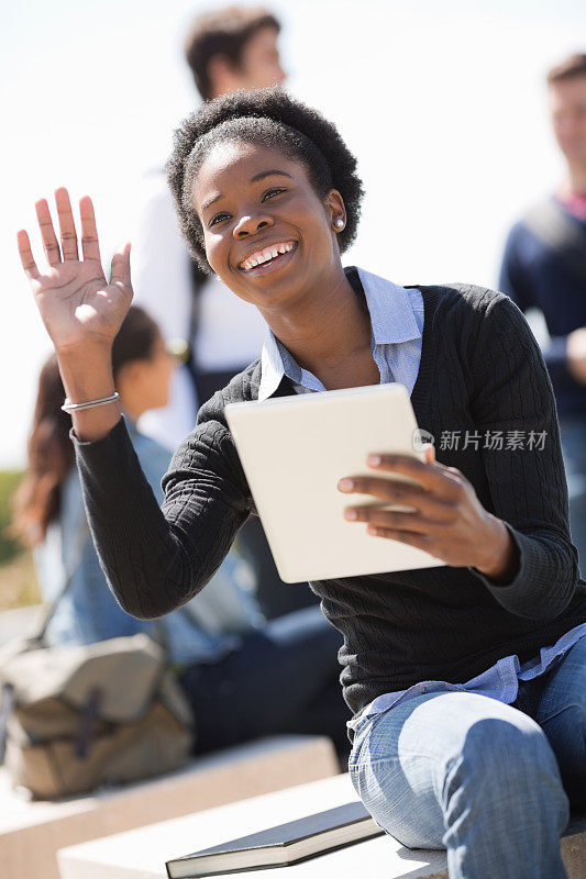 在校园里挥舞着平板电脑的女学生