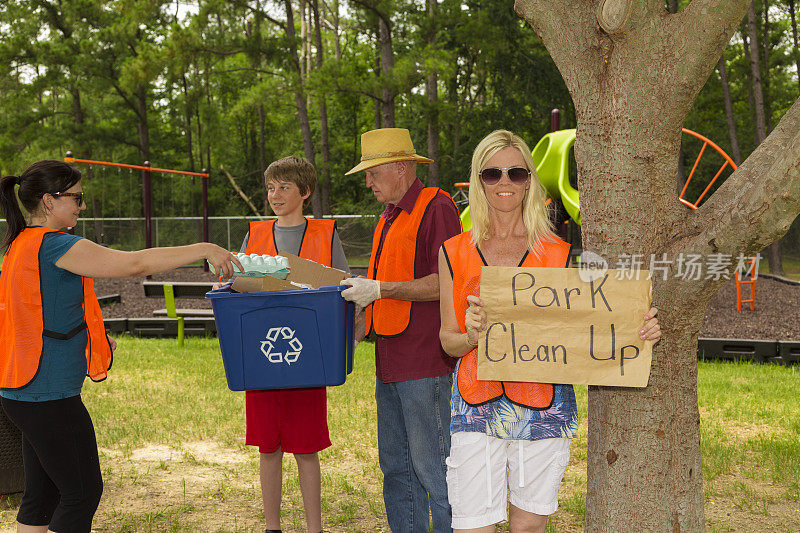 志愿者:微笑的妇女拿着公园清理牌。社区的参与。
