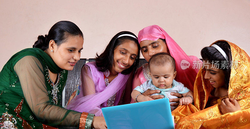 兴高采烈的印度家庭持有笔记本电脑