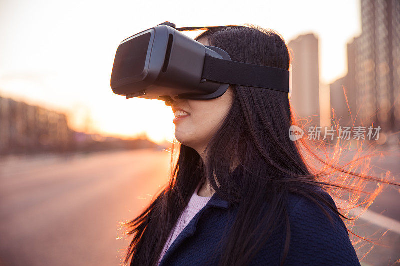 女人在日落时使用虚拟现实头盔