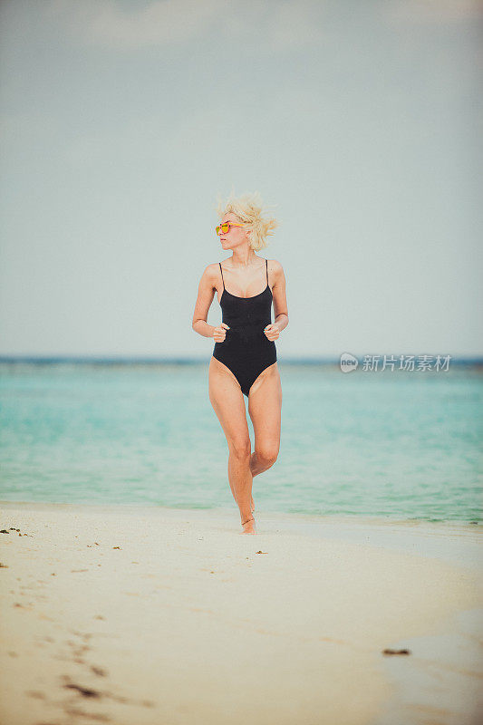 在马尔代夫海滩上，一名女子在水中奔跑