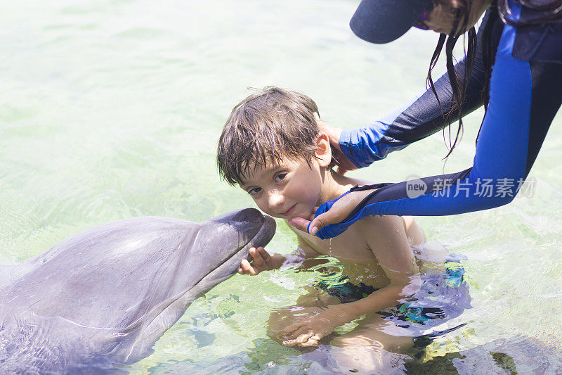 假期生活方式-快乐男孩拥抱海豚