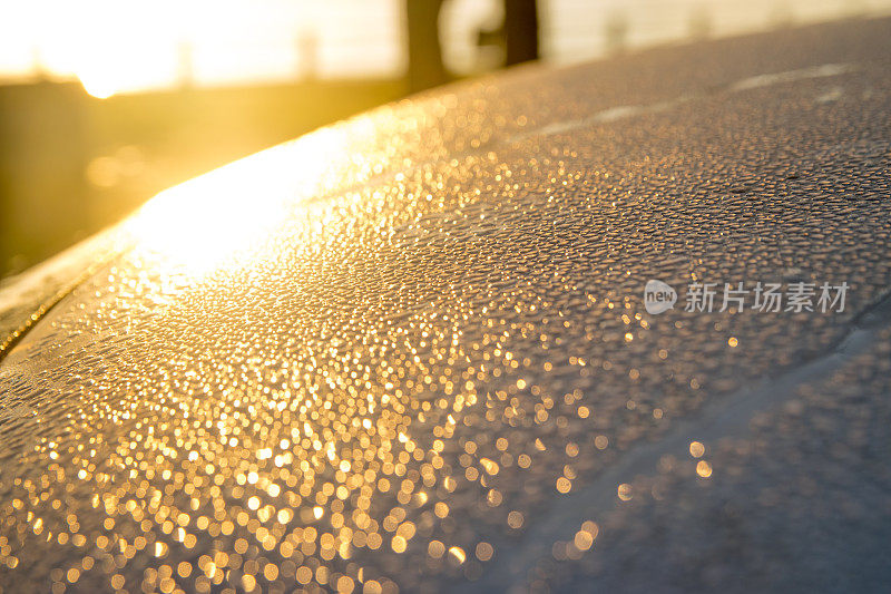 冬天早晨阳光洒在车顶上的水滴