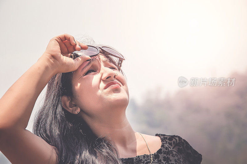 户外夏天的肖像年轻女孩在黑色的护目镜遭受太阳的热量