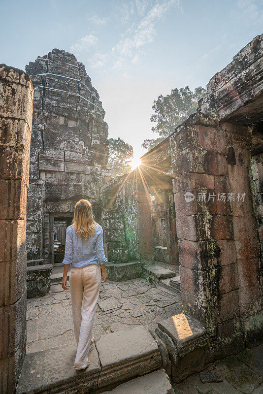 女游客漫游在古老的寺庙日落享受发现和旅游在亚洲，柬埔寨吴哥窟