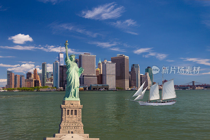 自由女神像，帆船(高船)，纽约港的水，天际线与曼哈顿金融区和世界贸易中心，布鲁克林大桥和蓝天，纽约市。