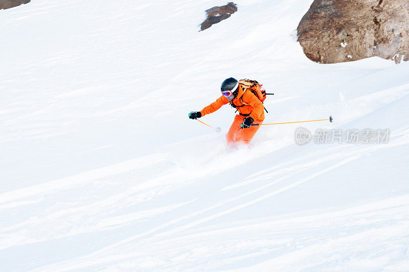 滑雪运动员在一个新雪粉冲下雪坡