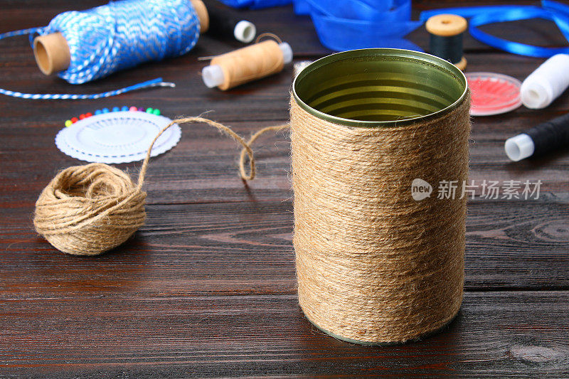 在木桌上用绳子裹着一个铁罐。手工制作的。
