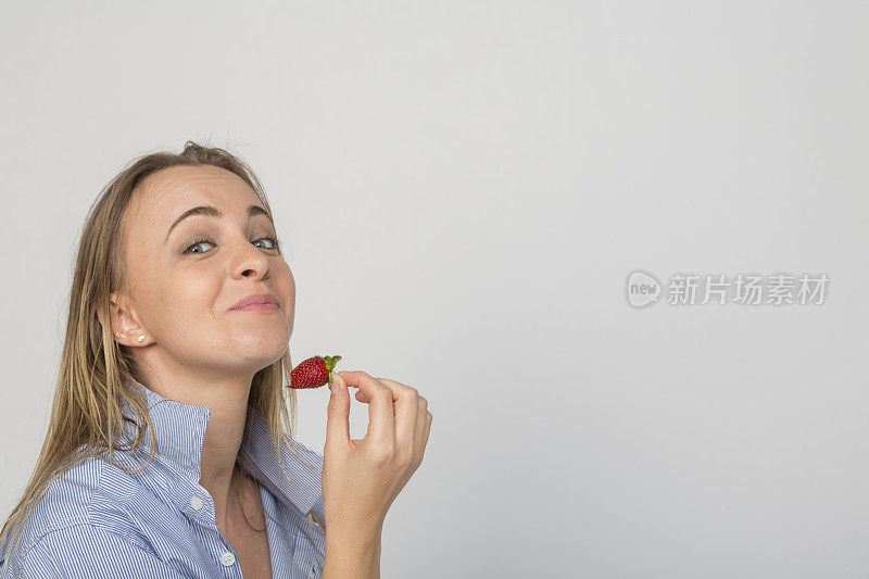 在土耳其伊斯坦布尔的工作室里，年轻的乌克兰女子正在吃新鲜的草莓