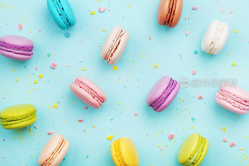 彩色的马卡龙蛋糕或马卡龙在绿松石粉背景。法式杏仁饼干甜点俯视图。