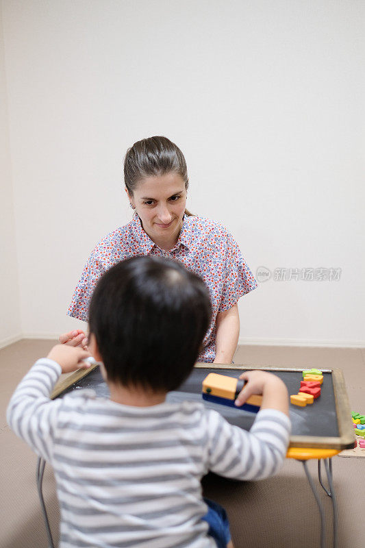 白人妇女用黑板教小孩英语