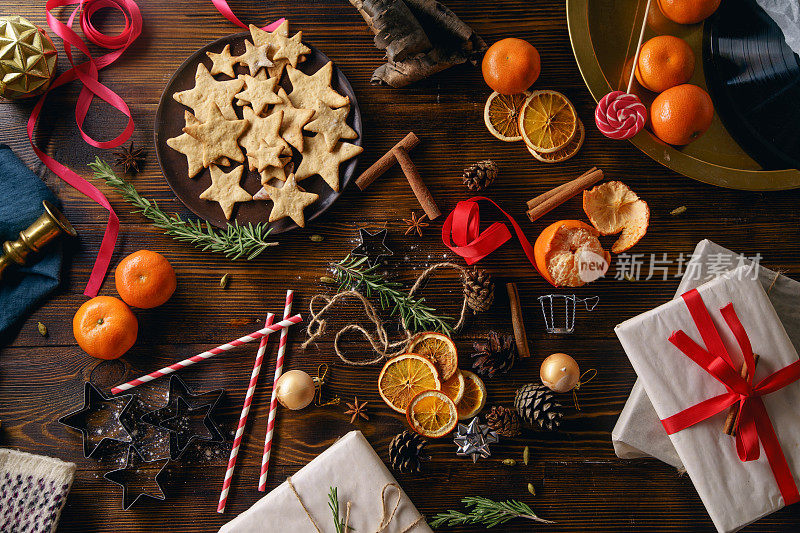 圣诞气息flatlay。顶视图。姜饼、橘子和木制背景的新年装饰品