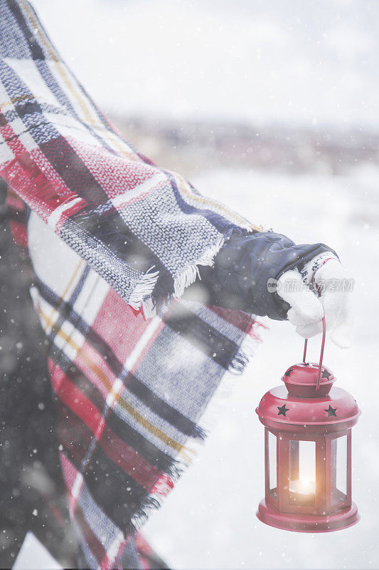 年轻女子在雪地里提着灯笼