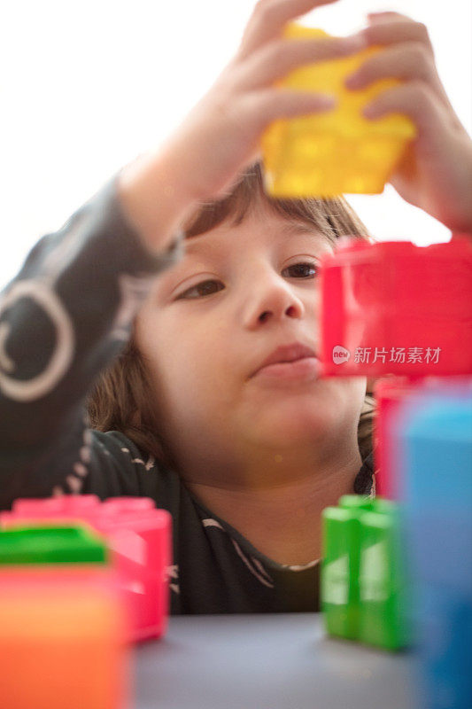 小男孩用塑料玩具积木建造。