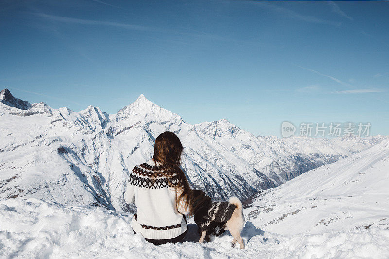 女人和狗享受瑞士阿尔卑斯山的冬季景色