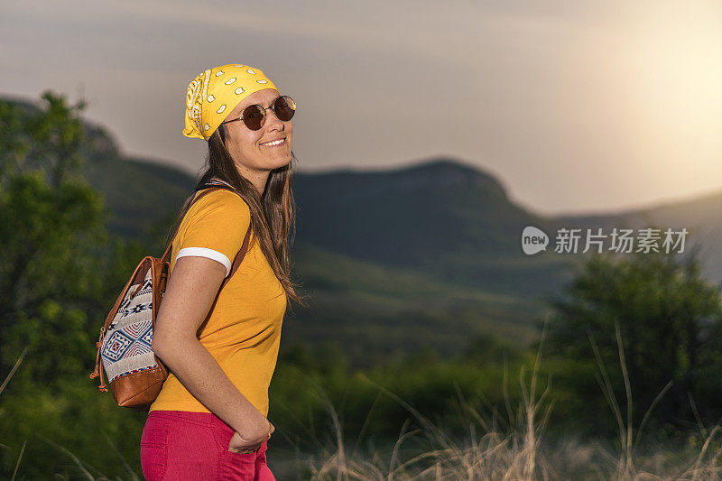 在春天搭便车。在大自然中享受阳光的女孩。