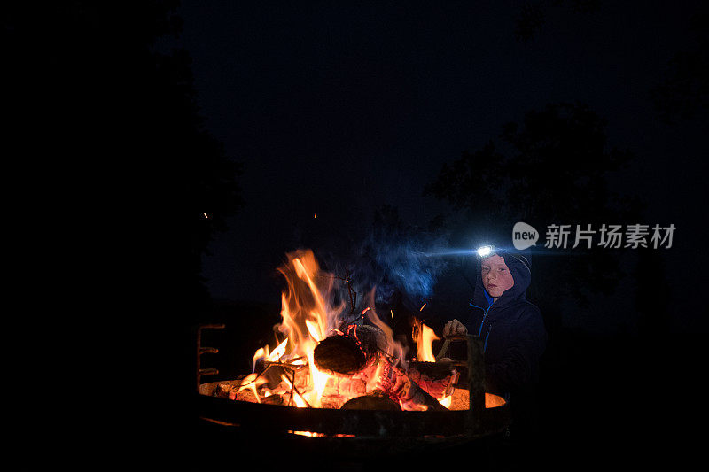 这个小男孩喜欢在营火旁玩