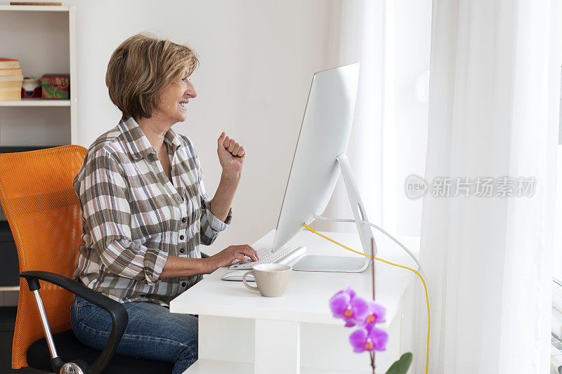 年长妇女在家里使用电脑