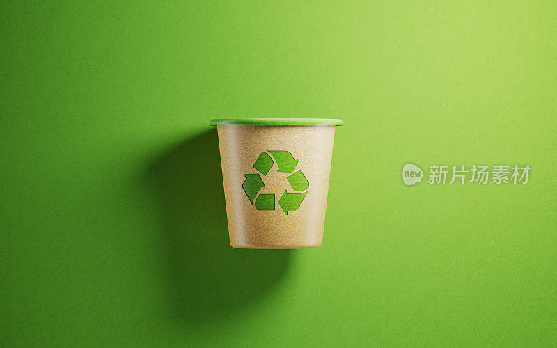 绿色背景的再生纸制成的垃圾桶