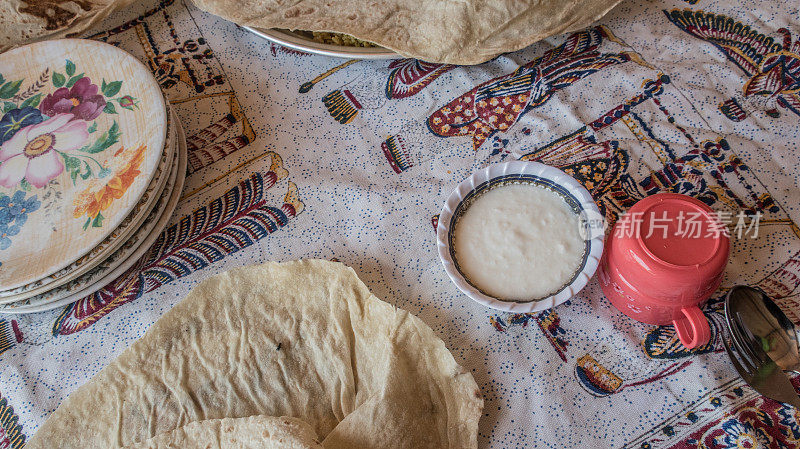 传统的伊朗游牧餐，扁豆和香草米饭，塔夫顿面包和羊奶