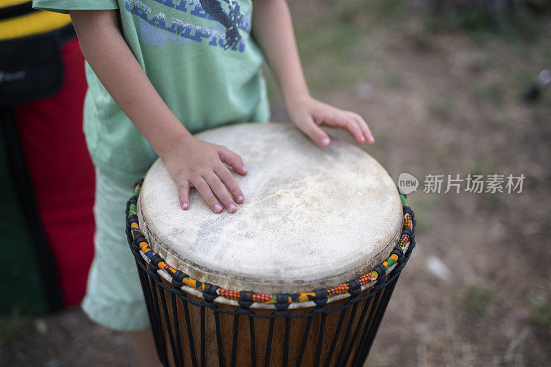 孩子在玩djembe。