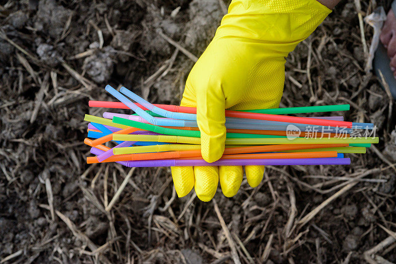 手持塑料吸管手套的手的特写——生态产业理念