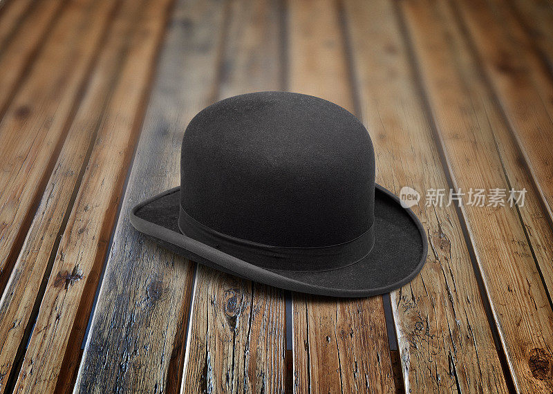 一顶时尚的黑色圆顶礼帽放在有纹理的木桌上