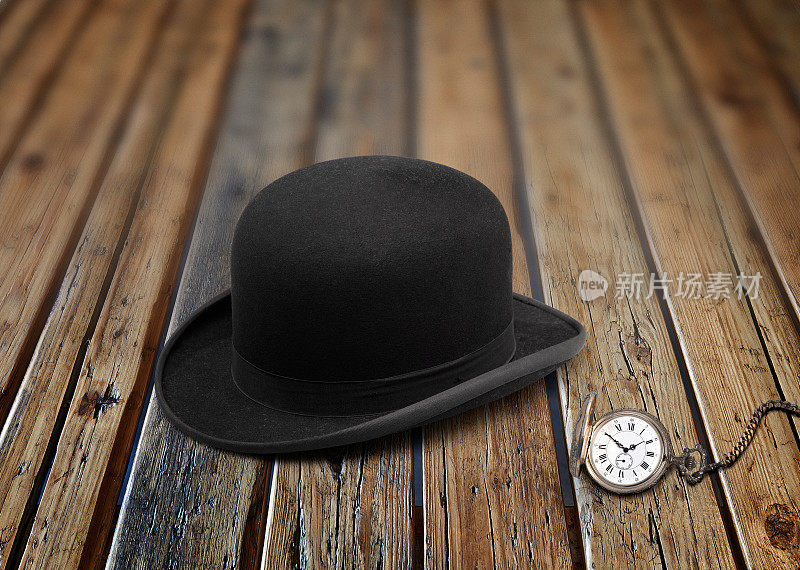 一顶时髦的黑色圆顶礼帽和老式钟