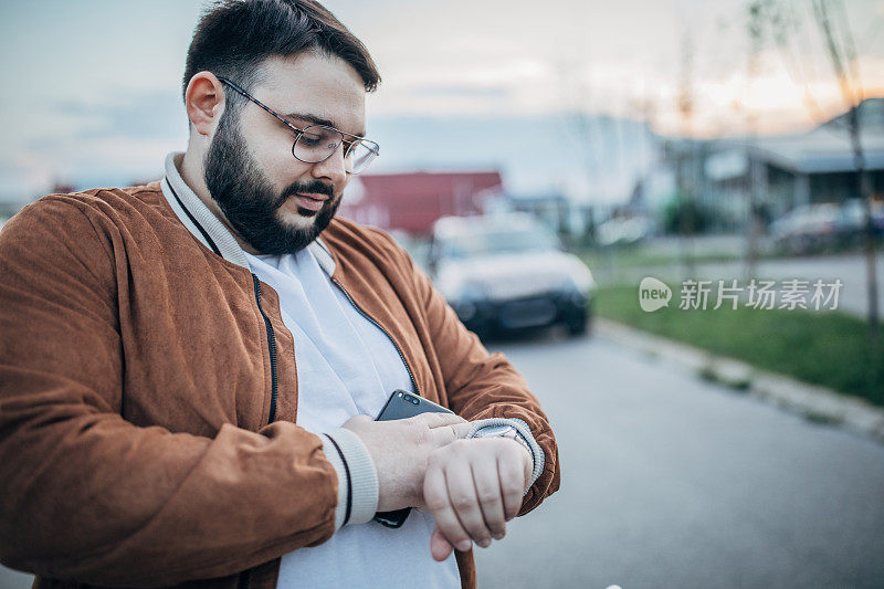 大胡子站在街上看时间