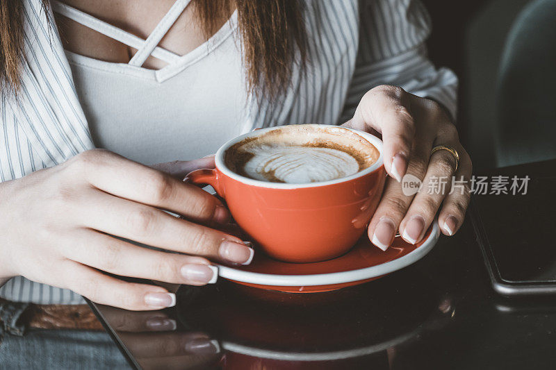 一个女人正在享用一杯咖啡，网址是Café