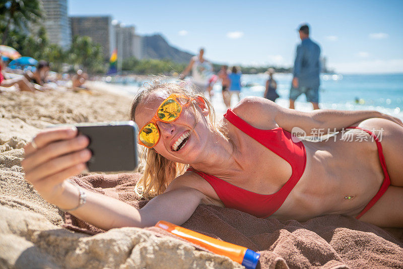 年轻女子在檀香山美丽的海滩自拍照片，夏威夷，美国