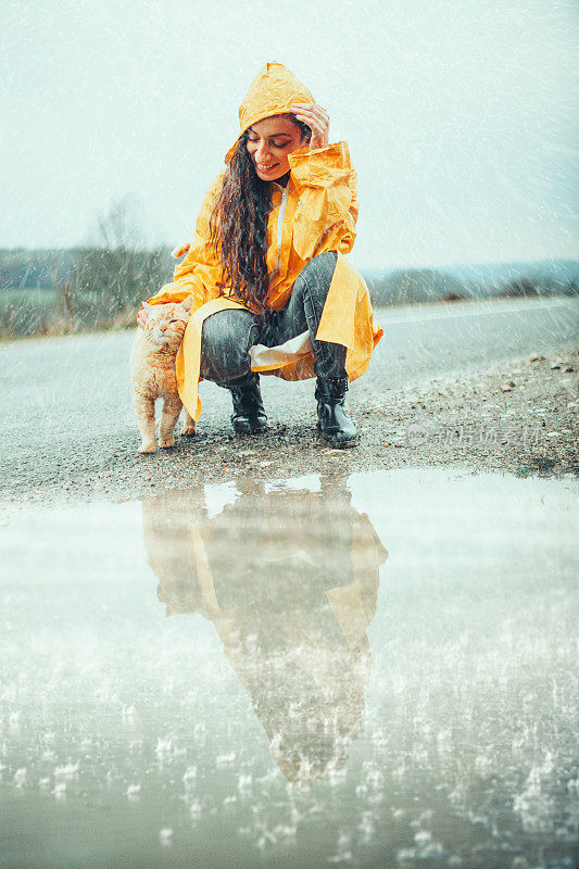 快乐的女孩和猫在大自然的雨