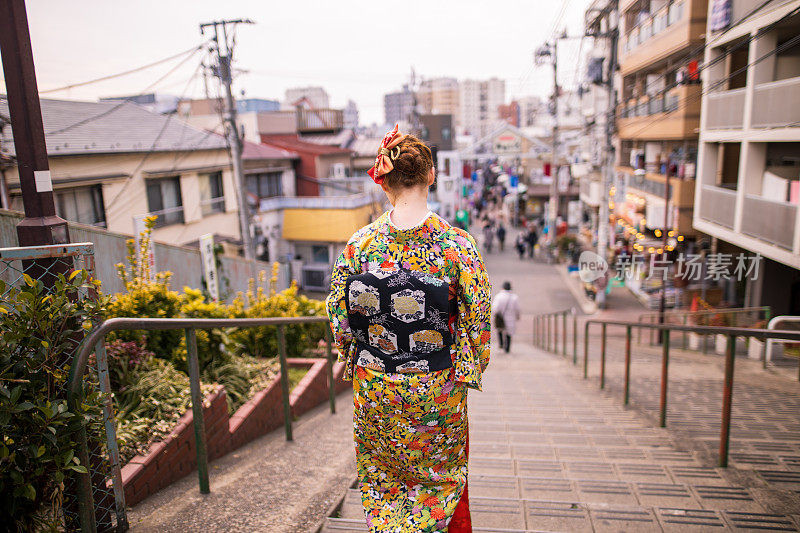 穿着和服的年轻白人女子走下楼梯