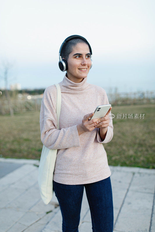 年轻女子在户外用手机听音乐