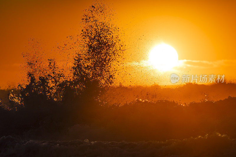 初升的太阳映出浪花的轮廓