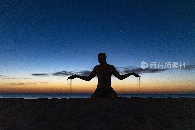 在海滩上做瑜伽。夕阳西下，人在莲花中沉思。沙子从掌心流出