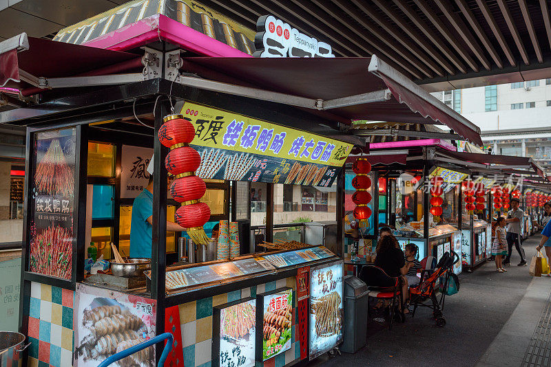 中国的街边小吃摊。小贩烹饪和销售