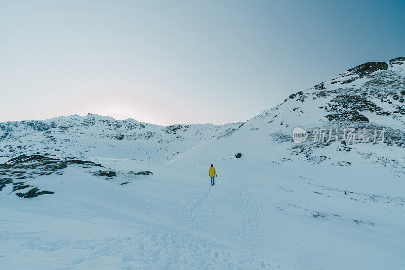 一个女人在罗弗敦岛的雪山中行走