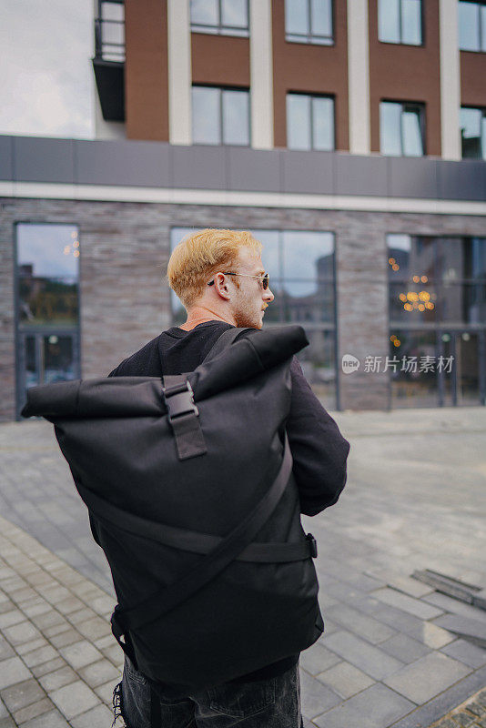 背着背包的男人走在街上