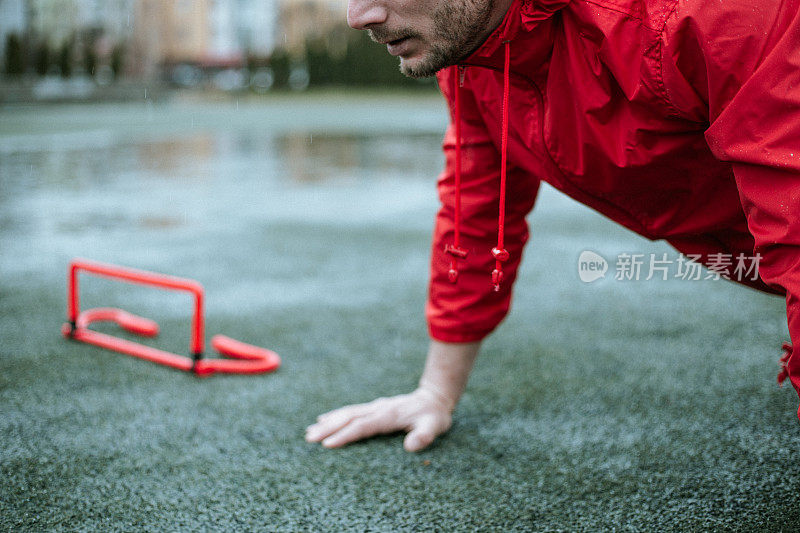 下雨天，穿着红色风衣的人正在训练