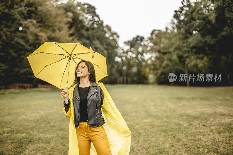 年轻快乐情绪开朗的女孩微笑着撑着伞在大自然中