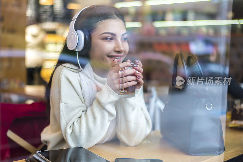 在大街上的咖啡馆里喝茶的漂亮女人