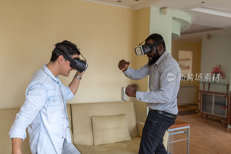 年轻的蓄着胡须的非洲裔美国人和他的朋友正在享受VR眼镜带来的乐趣。未来已经到来。