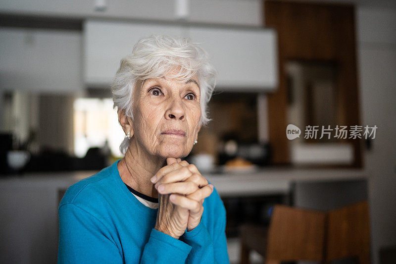 忧心忡忡的老妇人在家沉思祈祷