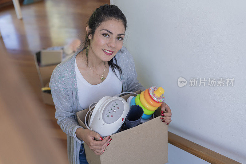 一个年轻女人的肖像非常高兴地到达她的新房子，并把她的货物回家