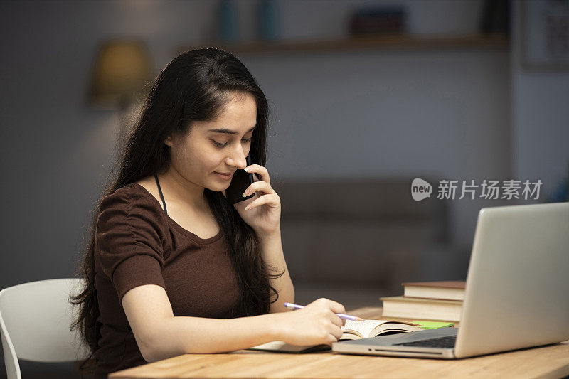 年轻女性在家工作(用电脑)的库存照片