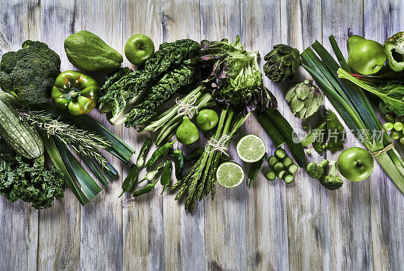 表顶视图背景变化绿色蔬菜排毒和碱性饮食。放在一张白色质朴的桌子上，有复印的空间