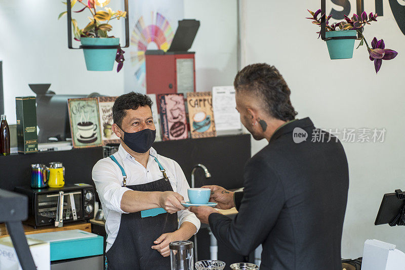 一家咖啡工厂的拉丁裔雇员站在为顾客准备咖啡的酒吧里