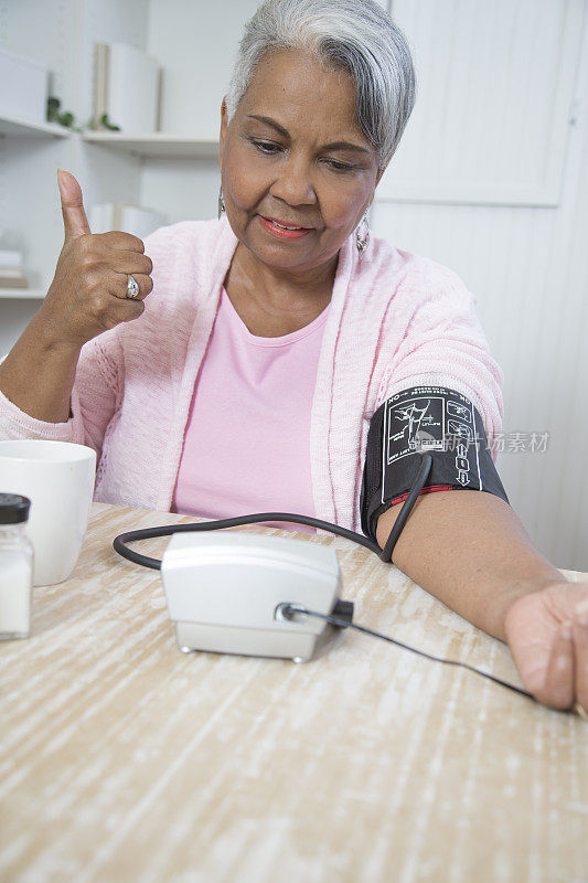 一位可爱的老年非裔美国妇女在监测她的血压。